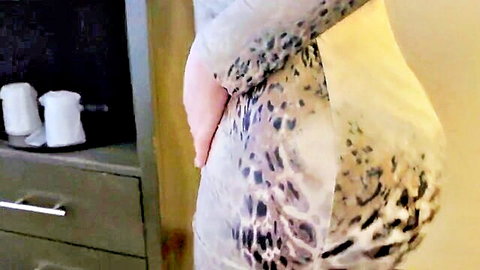Curvy woman in tight leopard dress posing seductively from behind