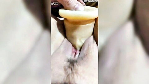 Mature woman getting large condom-covered penis insertion close-up