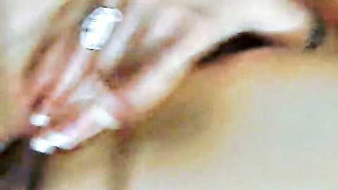 Blurry close-up of woman's hand with diamond ring touching skin in orgy scene