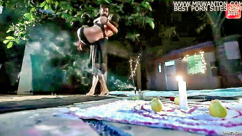 Indian couple in outdoor tantric yoga embrace with ritual elements
