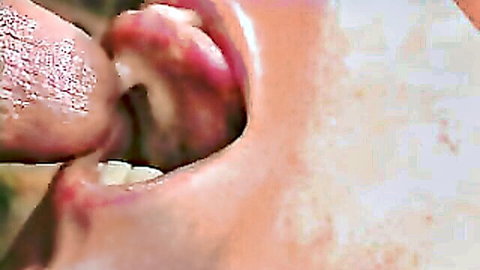 Close-up of woman with cum on open mouth and tongue, finger pressing in