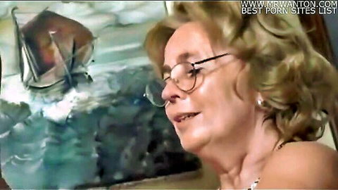 Blonde mature granny with glasses in seductive roleplay pose