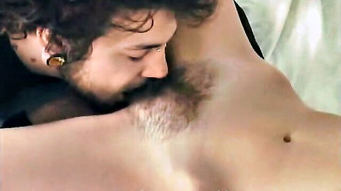 Bearded punk guy intimately nuzzling shirtless hairy partner's neck