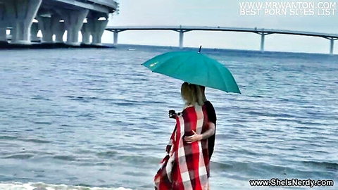 Iris Kiss Kiss nerdy blonde wrapped in blanket with man by seaside under umbrella