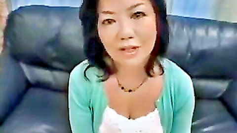 Mature Japanese woman in green cardigan with cleavage tease