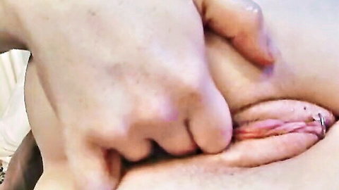 Close-up of redhead in glasses spreading her pierced pussy during vibrator insertion