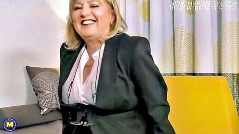 Smiling blonde MILF in sexy black business suit and blouse