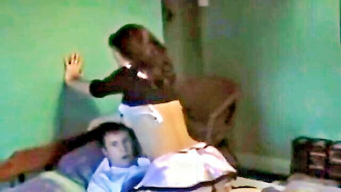 Brunette maid in apron bends over exposing bare ass to man lying on bed below