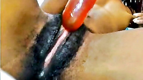 Hairy black pussy close-up with red dildo insertion in amateur scene