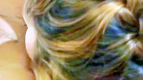 Sexy blonde with blue streaked wavy hair close-up in steamy threesome
