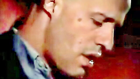Close-up of handsome man with lip piercing smirking passionately