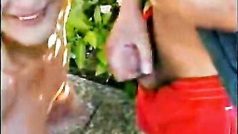 Blonde smiling in garden giving handjob to erect cock outdoors