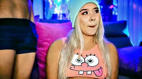 Blonde Colombian beauty in SpongeBob top teases with man in shorts behind her