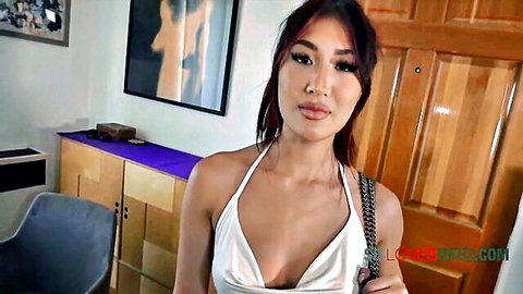 Petite Asian teen with long hair and deep cleavage in skimpy white halter top teasing her perky tits