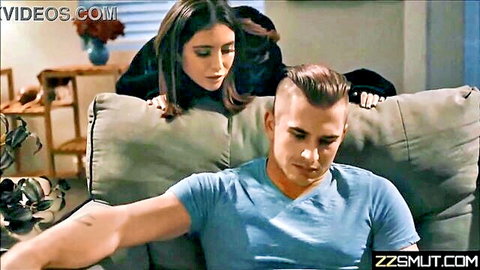 Brunette woman leans over muscular man in tense intimate couch moment