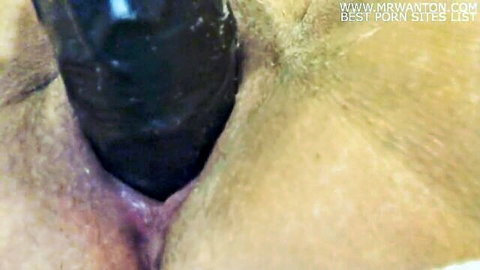 Close-up of woman fucking black dildo in pussy