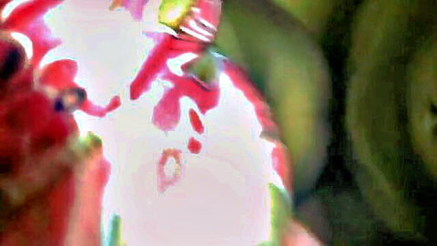 Blurry close-up of glossy red chili pepper with green stem and highlights