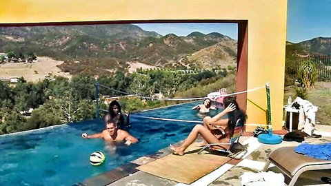 Interracial pool party with bikini-clad women and shirtless men lounging by the pool