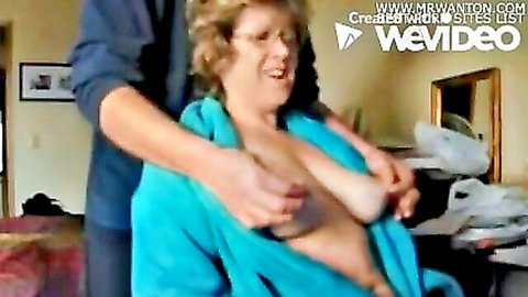 Man fondles Mrs Hg's large breasts while she smiles in open towel