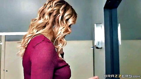 Giselle Palmer in tight maroon sweater, blonde waves, seductive bathroom mirror pose
