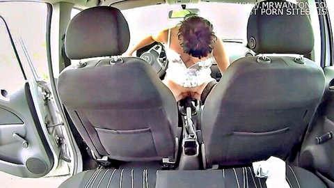 Brunette in white lingerie inserts pink dildo deep into wet pussy while squatting on car seat