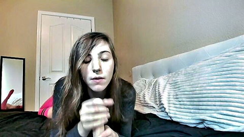 Brunette teen with braces smiles playfully on bed, teasing dildo fun