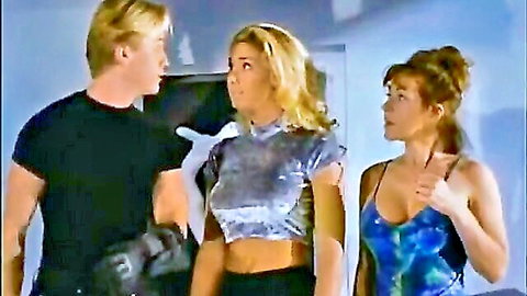 Blond guy chatting up two hot blondes in sexy tops from Femalien 2 (1998)