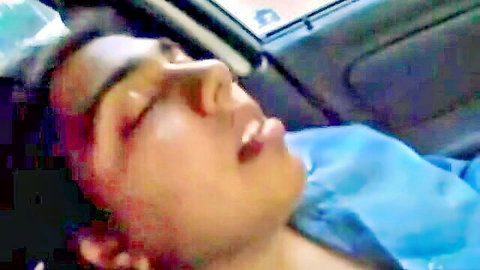 Seductive Indian woman asleep in car, eyes closed, lips parted, blue top