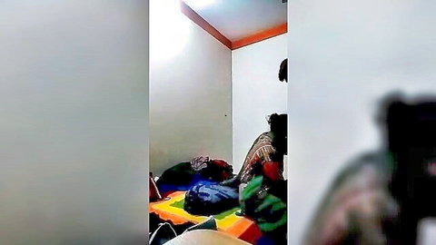 Blurry amateur scene of Indian woman and boy sitting on mat in room