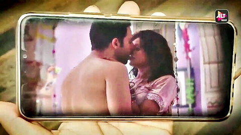 Indian couple passionately kissing, man shirtless, woman in pink ethnic dress
