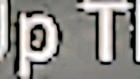 Blurry white outlined letters spelling UPT on gray background