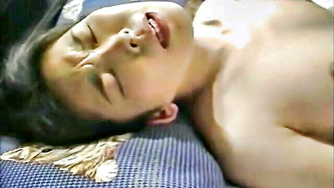 Young Japanese man lying shirtless with aroused expression in JAV scene