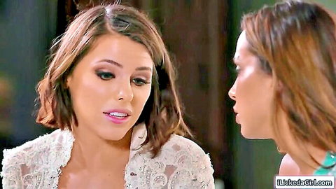 Intimate close-up of bride in white lace and bridesmaid facing each other