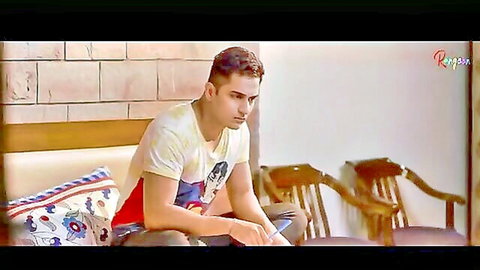 Handsome Indian man in white tee sits pensively in Rangeen Hindi web series Laddu (2021)