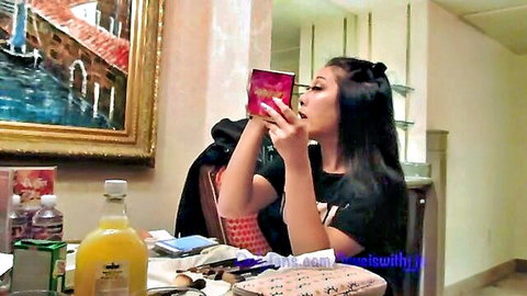 Asian beauty in black top applying lipstick, prepping for BBC in Reno