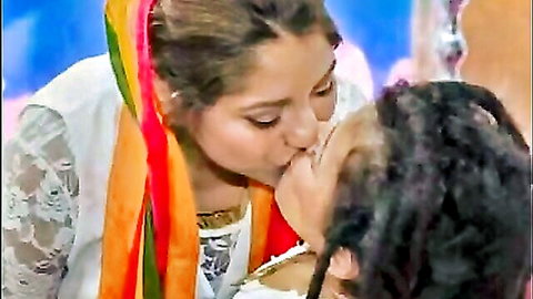 Brunette lesbian passionately kissing dreadlocked woman in colorful scarves and lace top