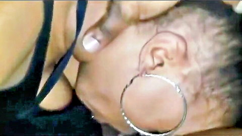 Ebony woman with hoop earrings and cleavage in black top close-up