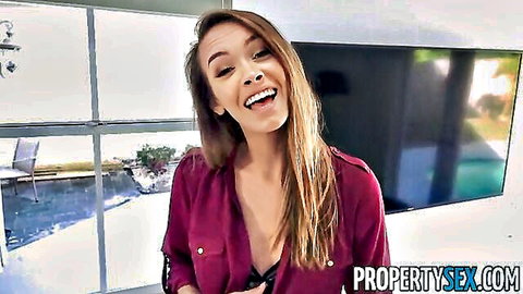 Charity Crawford smiles seductively in red blouse, real estate tease