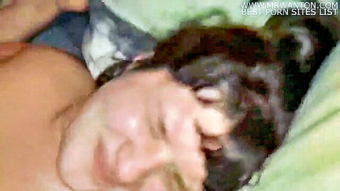 Topless white wife cuddling older black man in bed, smiling intimately