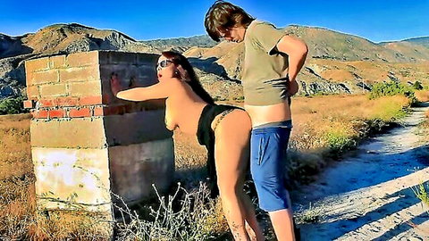 Latina big tits babe bent over outdoor brick wall exposing big ass in thong as guy stands behind with shorts down ready to fuck.