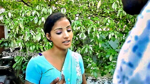 Young Indian brunette in blue saree smiling romantically at lover outdoors