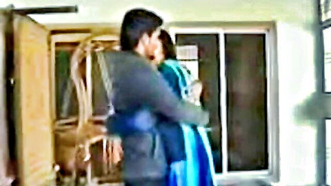 Indian boyfriend passionately hugging girlfriend in blue saree from behind