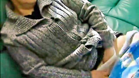 Asian woman in gray cardigan lying with visible white diaper, solo fetish pose