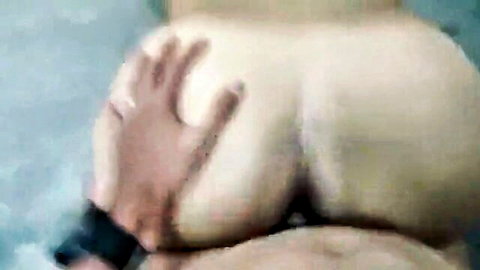 Close-up of man gripping pale woman's round ass in pool, teasing foreplay