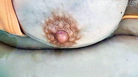 Close-up of exposed large pale breast with pink nipple at the pool