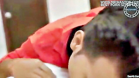 Indian woman in red saree lying intimately with man on bed