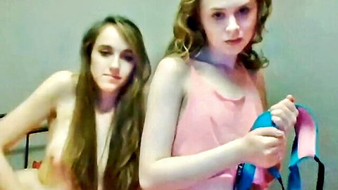 Skinny topless teen exposing small natural tits with blonde girlfriend holding blue straps on webcam