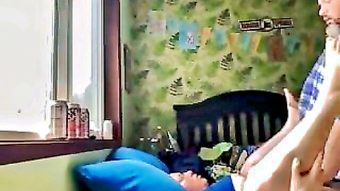 Blonde woman lies on bed legs spread wide exposing shaved pussy fingered by hand with tits out