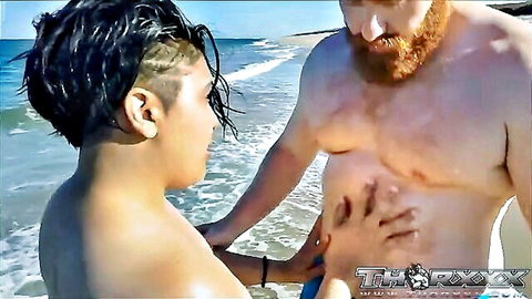 Muscular redhead bear nipple play with slim partner on beach