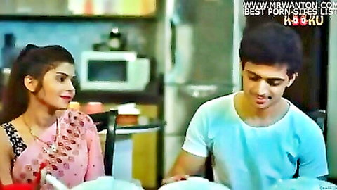Indian woman in pink saree smiles flirtatiously at young guy in kitchen teasing rough sex